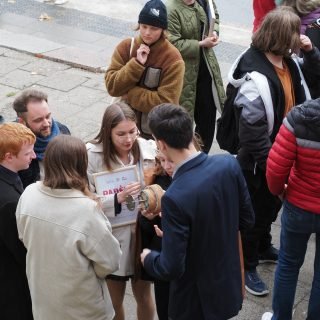 Mokinių grupė Neries pakrantėle susidomėję tyrinėją ssiųstuvą